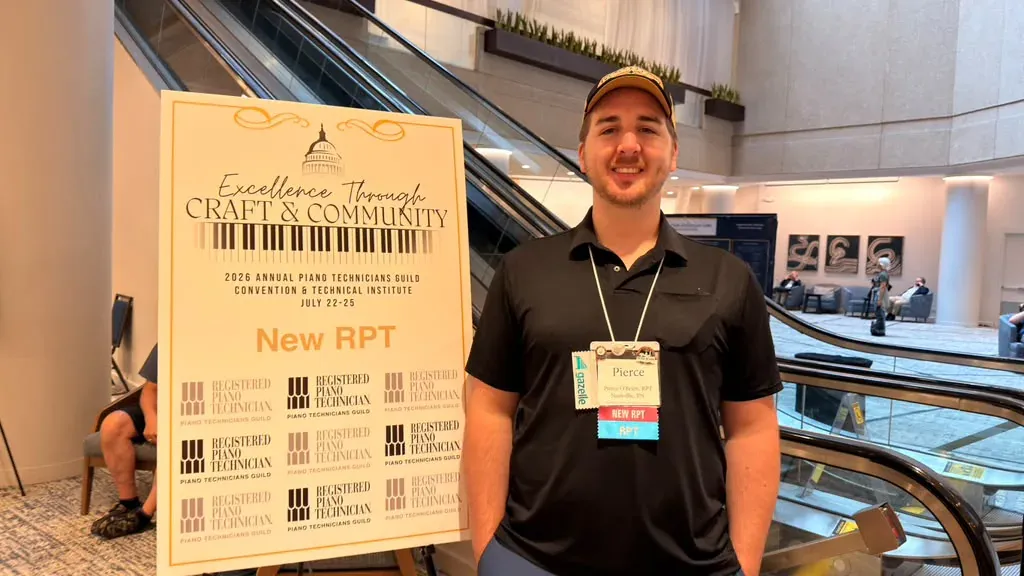 Pierce O’Brien beside a Registered Piano Technician convention display